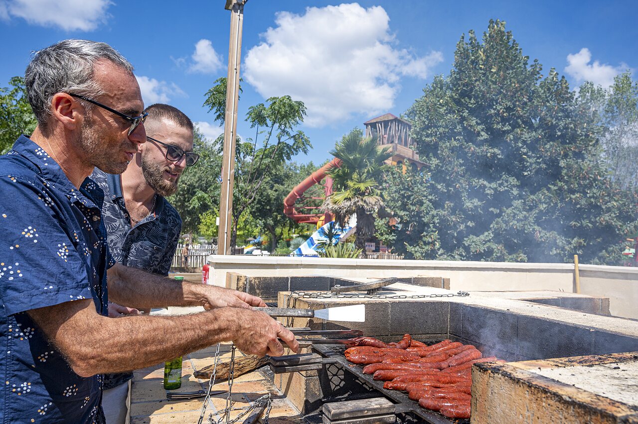 Friendly barbecue with sausages, water slides at CAPFUN Soubeyranne campsite in REMOULINS (30).