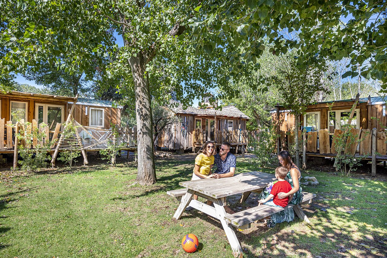 Wooden Mobil-homes, family, greenery at CAPFUN Soubeyranne campsite in REMOULINS (30).