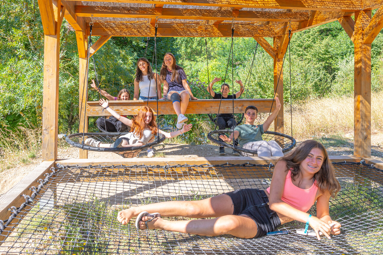 Young people on swings and play net at camping CLICOCHIC Source du Jabron in Comps (26).