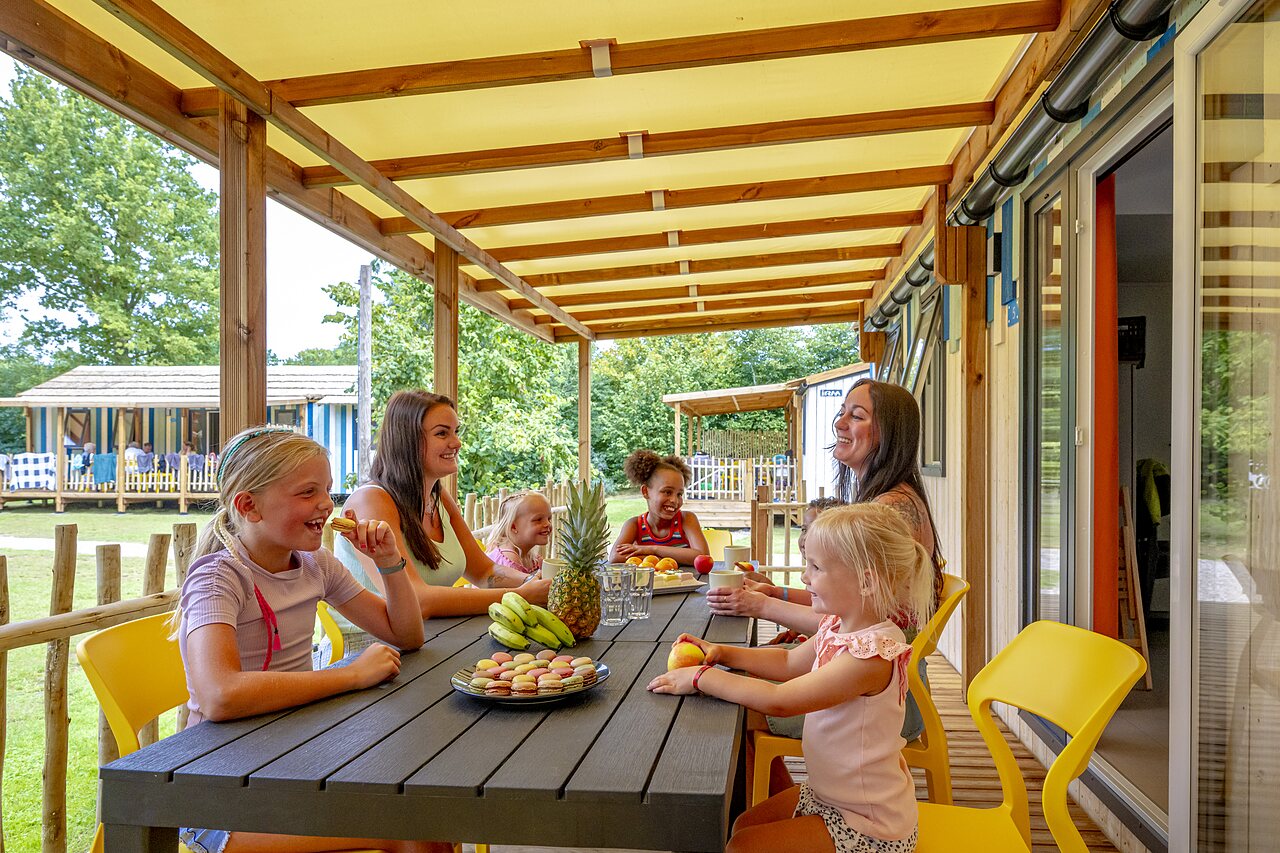Covered Mobile home terrace with family at CAPFUN Vakantiepark Capfun het Stoetenslagh campsite in Rheezerveen.