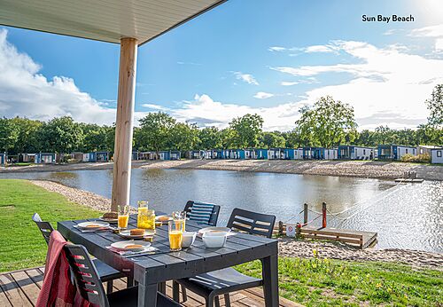 Breakfast on mobile home terrace with beach view at CAPFUN Vakantiepark Capfun het Stoetenslagh campsite in Rheezerveen.