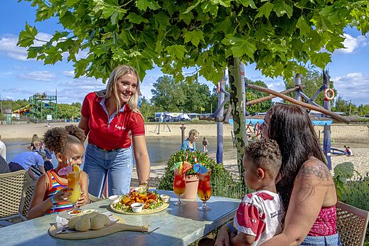 Family dining at restaurant with Capfun service at campsite CAPFUN Vakantiepark Capfun het Stoetenslagh in Rheezerveen.