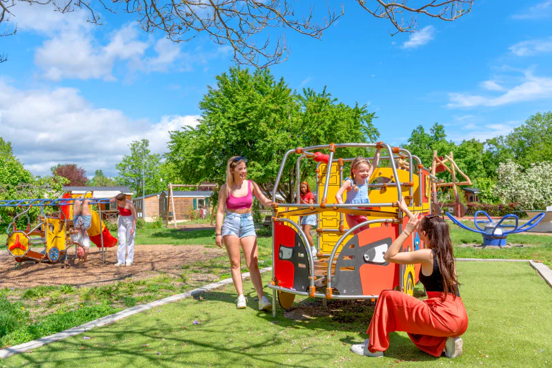 Colorful playground with children and adults at CAPFUN Suzel campsite in Sainte-Croix-en-Plaine (68).