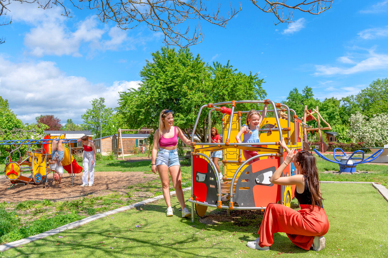Colorful playground with children and adults at CAPFUN Suzel campsite in Sainte-Croix-en-Plaine (68).