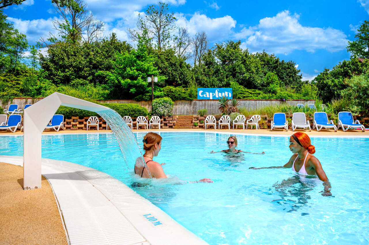 Outdoor pool with waterfall, swimmers at CAPFUN Suzel, Sainte-Croix-en-Plaine (68).