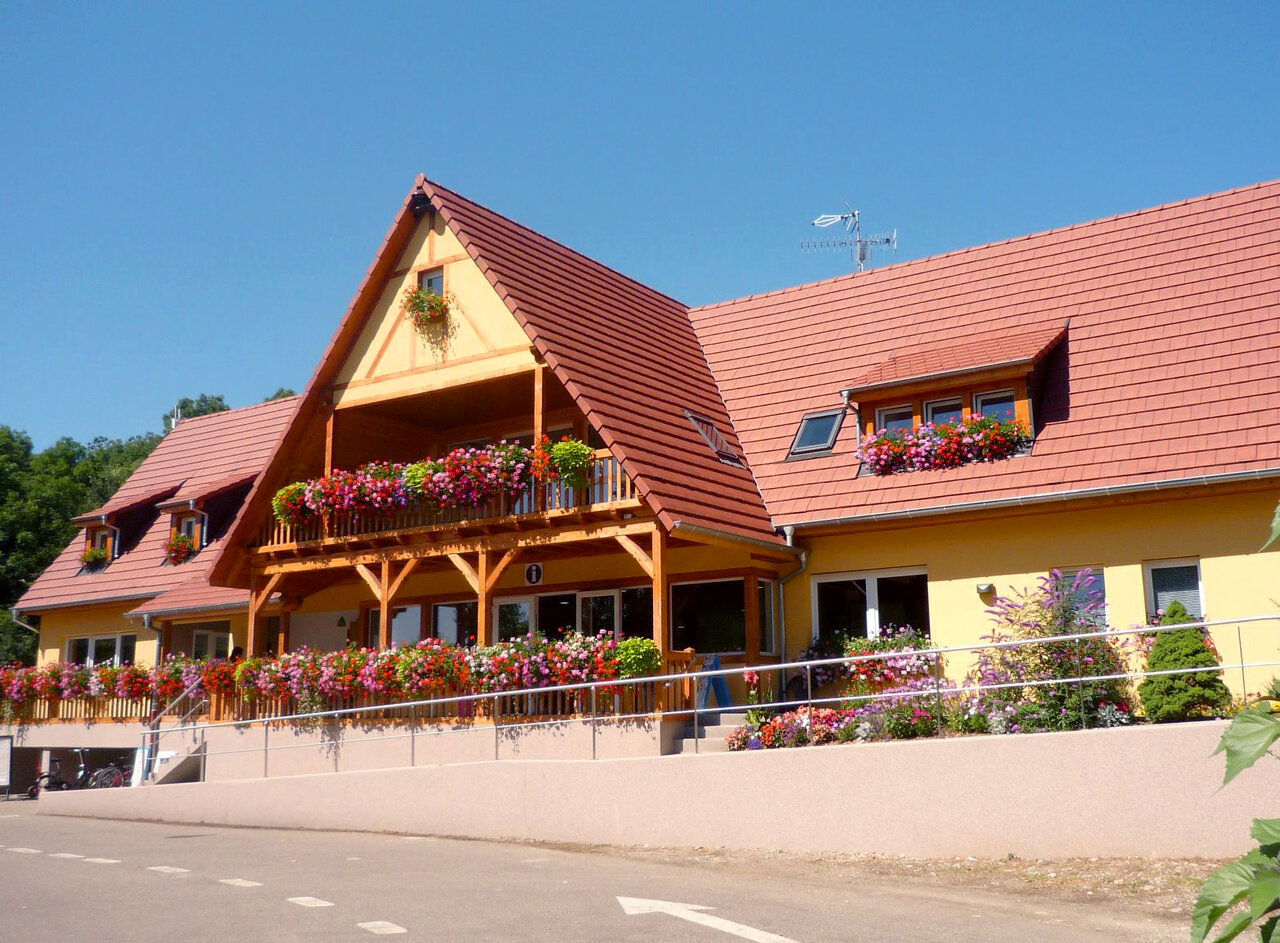 Flowered reception building and balcony at CAPFUN Suzel campsite in Sainte-Croix-en-Plaine (68).