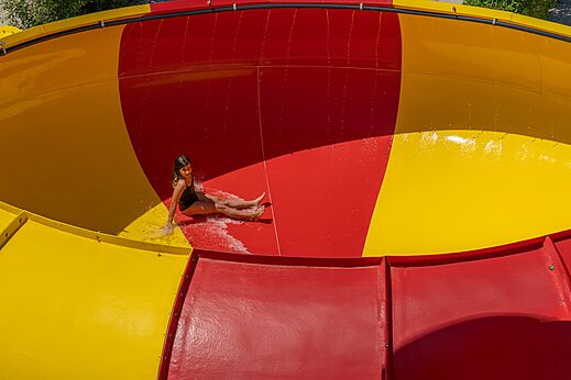 Girl on red and yellow water slide at CAPFUN Talaris Vacances, Lacanau (33).