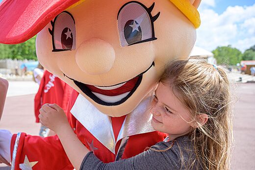 Child hugging the mascot at CAPFUN Talaris Vacances campsite in Lacanau (33).