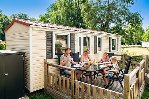 Family on Mobil-home terrace, breakfast at CAPFUN Tecklenburg campsite.
