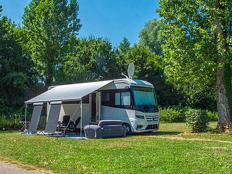 Large motorhome with awning and chairs on grassy pitch at CAPFUN Tecklenburg campsite in Tecklenburg-Leeden (49).
