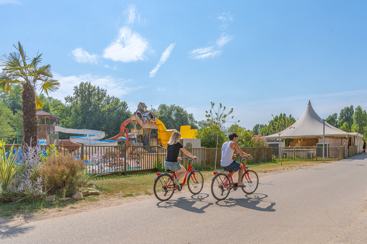 Water park, slides and cyclists at CAPFUN Temps Libre campsite in BOUGE CHAMBALUD (38).
