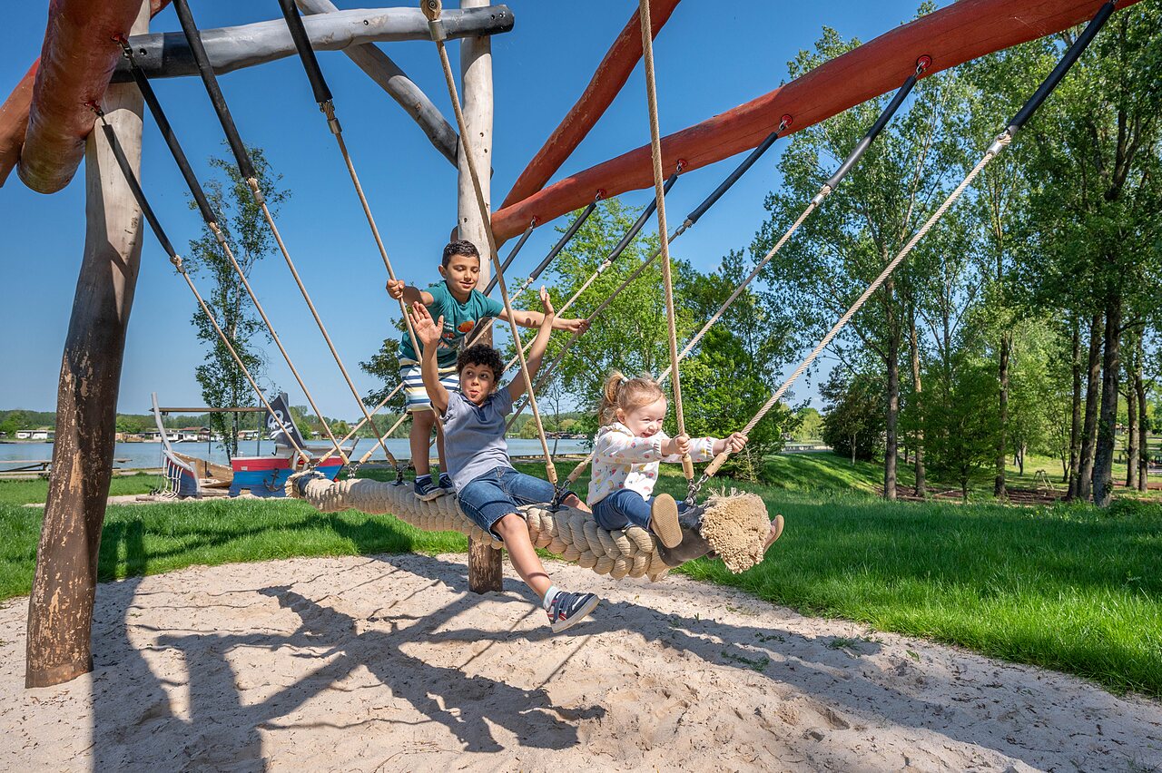 Children playing on large rope swing at CAPFUN Tensch Jolie, Grostenquin (57).