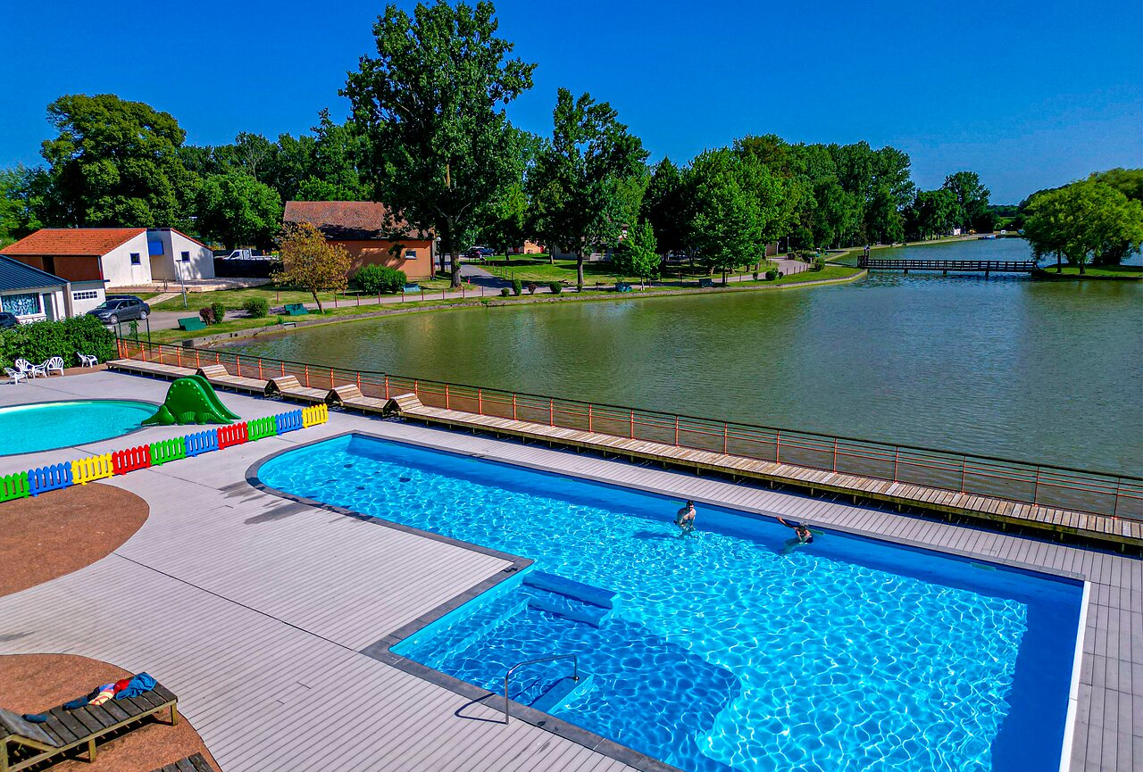 Outdoor swimming pool, slide and lake at CAPFUN Tensch Jolie campsite in Grostenquin (57).