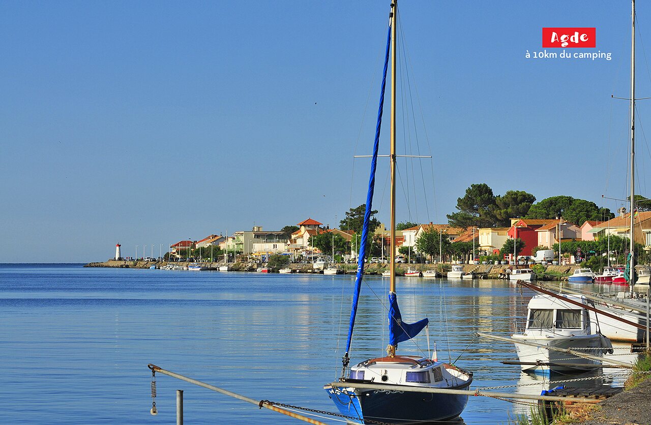 Agde harbor with sailboats, colorful houses and lighthouse, to visit near the campsite.