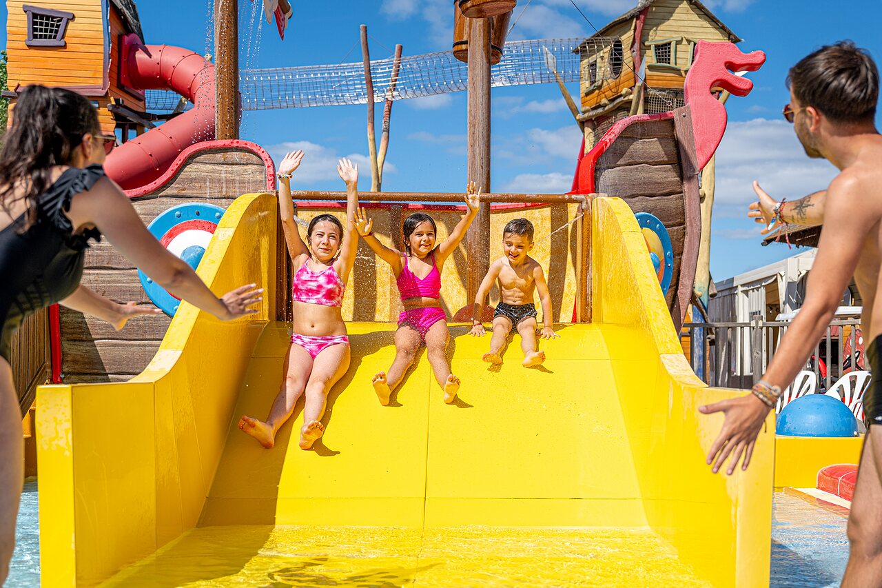 Children sliding yellow water slide at CAPFUN Teorix campsite in MARSEILLAN PLAGE (34).