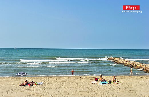 Fine sandy beach with sea, waves and swimmers at CAPFUN Teorix campsite in MARSEILLAN PLAGE (34).