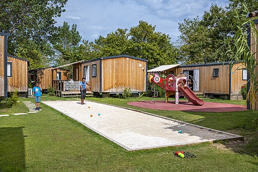 Petanque court with players and Mobile homes at CAPFUN Teorix campsite MARSEILLAN PLAGE.