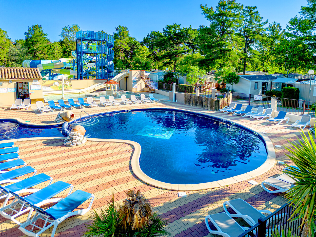 Outdoor swimming pool with water slides and sun loungers at CLICOCHIC Texas campsite in Argel�s sur Mer (66).