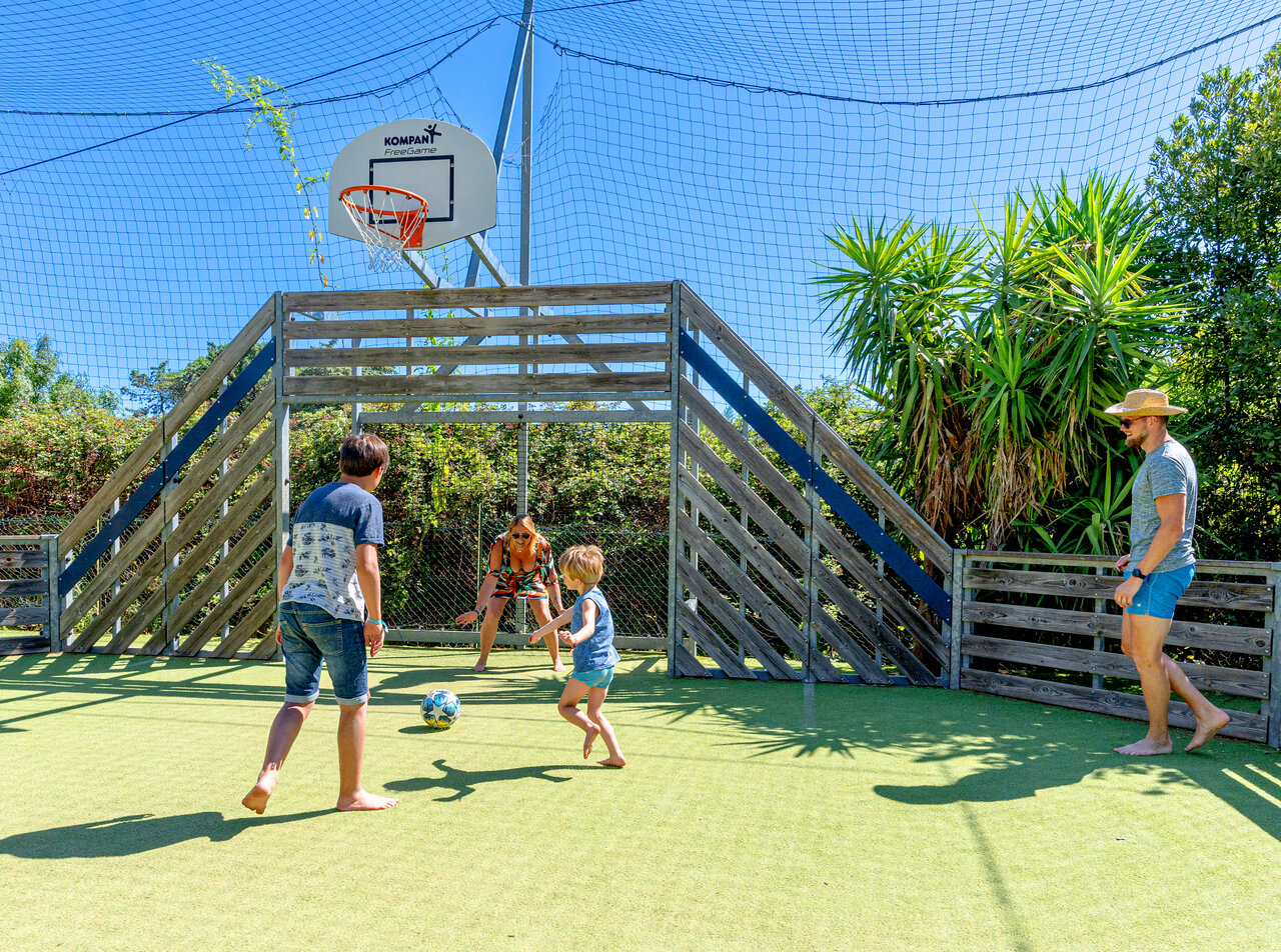 Family plays football on multi-sport pitch at camping CLICOCHIC Texas, Argel�s.