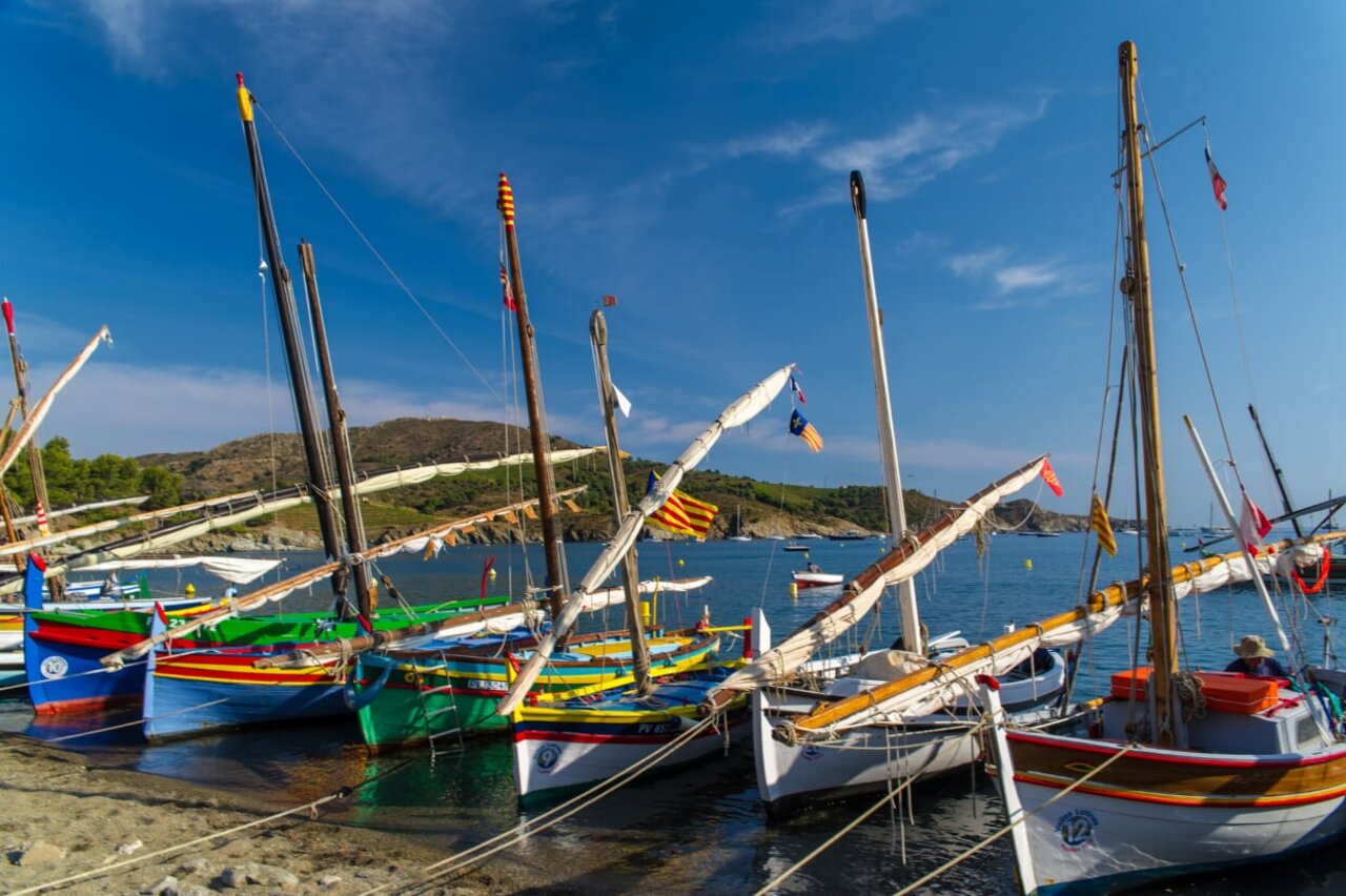 Colorful traditional boats moored in a sunny bay, camping CLICOCHIC Texas in Argel�s sur Mer.