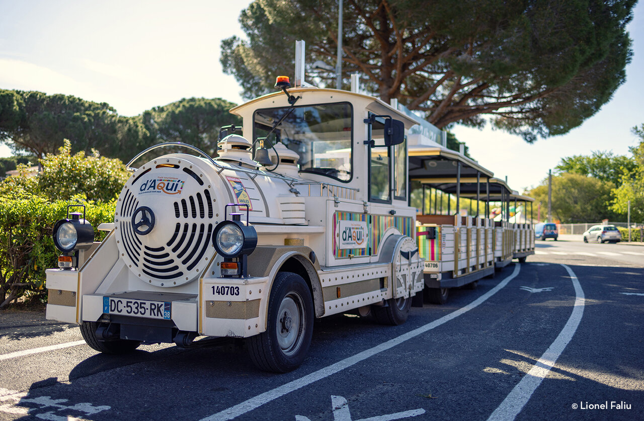 White tourist train with carriages in Angles, a nearby attraction.