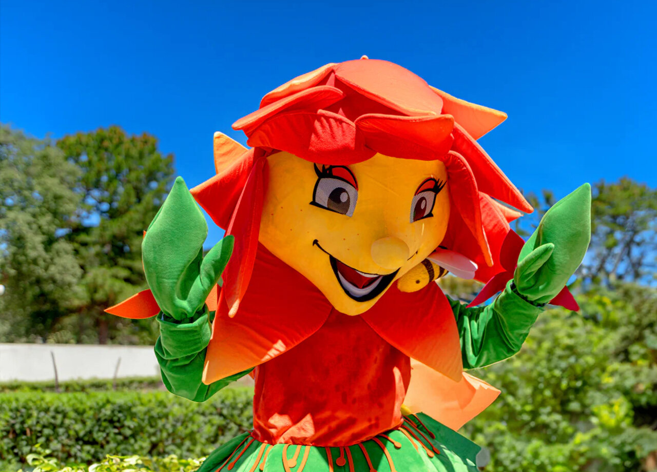 Smiling flower mascot for entertainment at CLICOCHIC Plage des Tonnelles campsite.