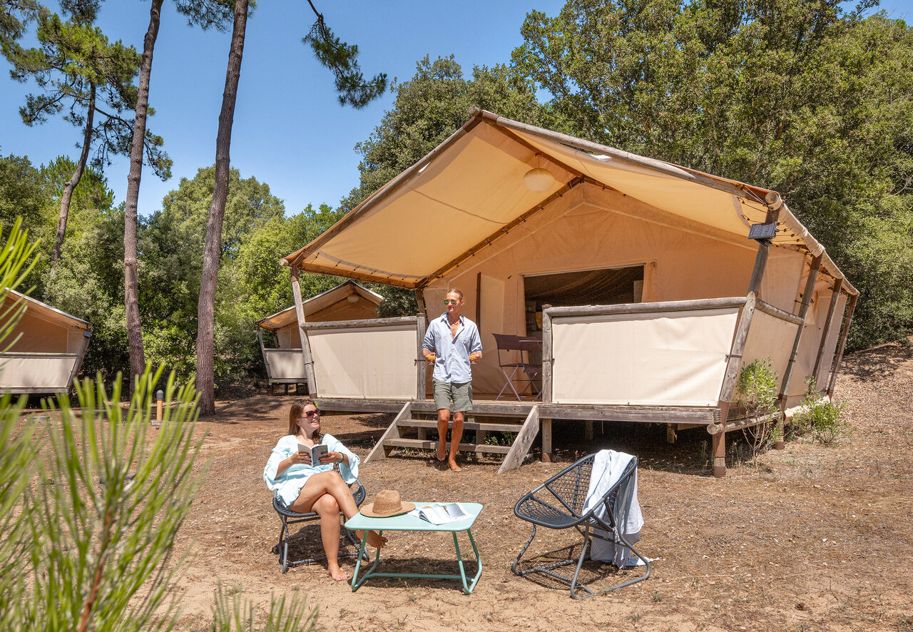 Couple relaxing at glamping lodge tent at camping CLICOCHIC Plage des Tonnelles (85).