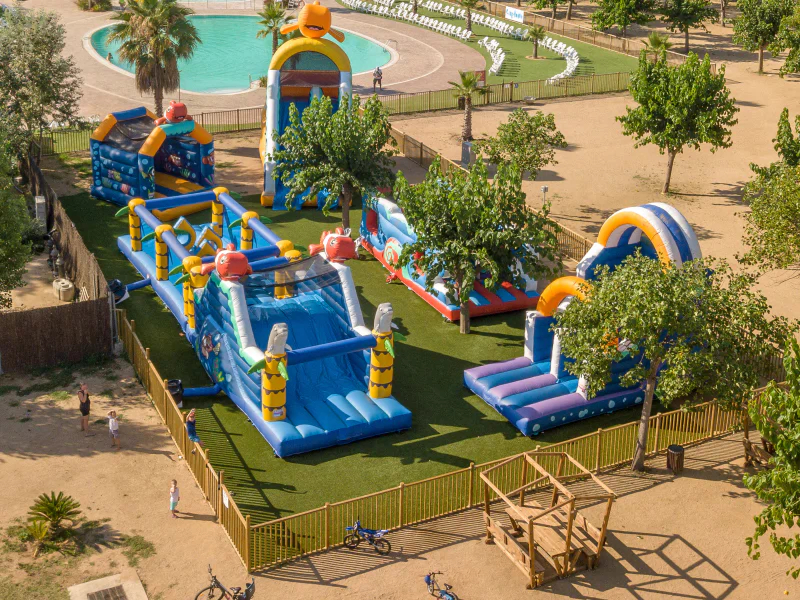 Inflatable play park, slides and swimming pool at CAPFUN Tordera-Nacions campsite.