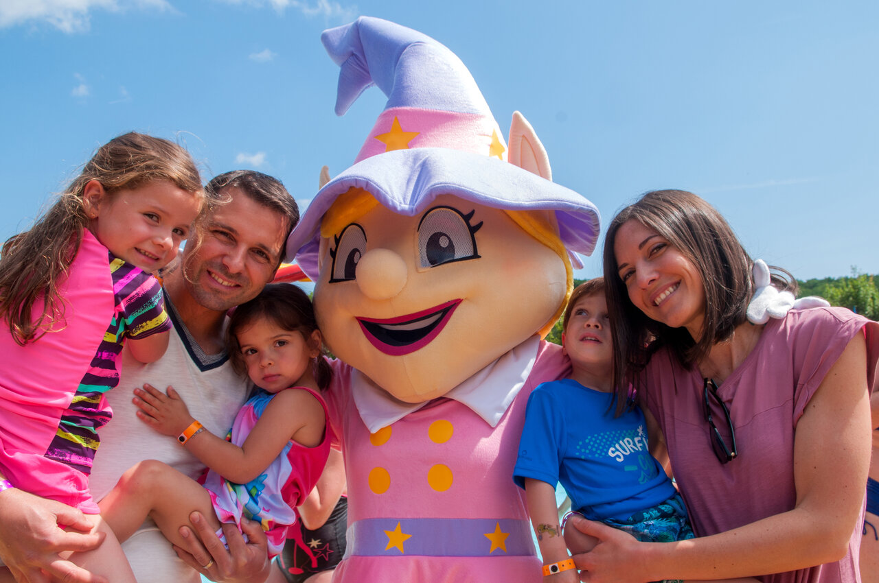 Smiling family with camping mascot, children's entertainment at CAPFUN Tordera-Nacions in Malgrat de Mar.