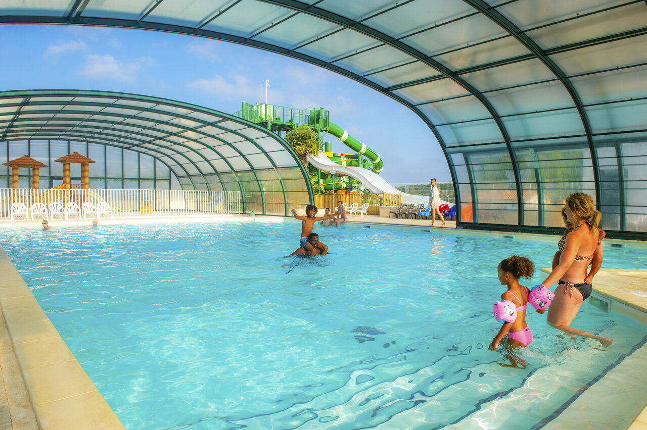 Covered swimming pool, water slide and children's games at CAPFUN Celeste campsite in Breuillet (17).