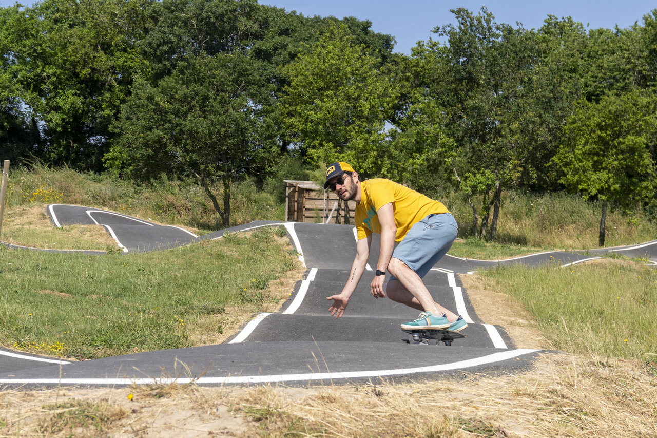 Man on skateboard on pump track at CAPFUN Celeste campsite in Breuillet (17).