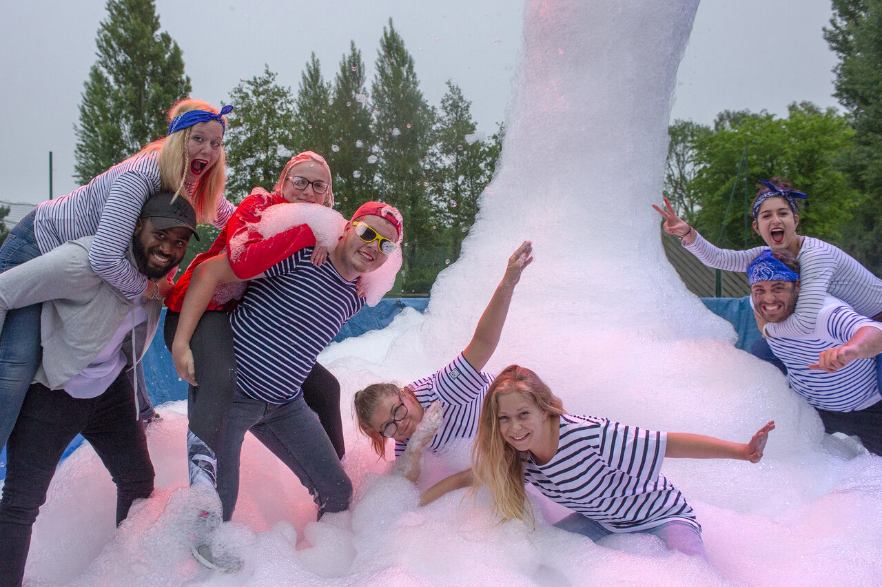 Lively foam party with smiling young adults at CAPFUN Celeste campsite in Breuillet (17).