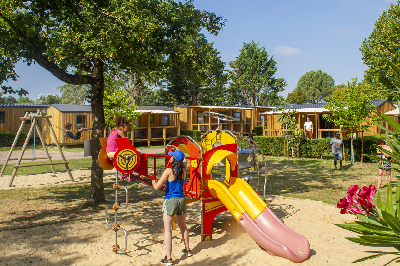 Playground with slide and swing, Mobile homes at CAPFUN Celeste campsite in Breuillet (17).