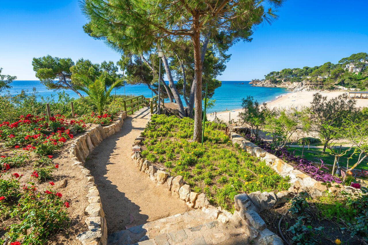 Beach, sea and flowery path at CAPFUN Treumal Platja d'Aro campsite.