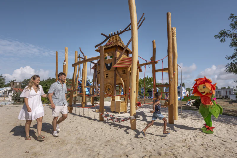 Large wooden playground, child, mascot at CLICOCHIC Trois Ch�nes campsite.