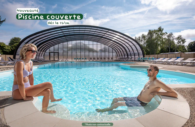 Covered swimming pool, smiling couple at CLICOCHIC Trois Ch�nes campsite, Pornichet (44).