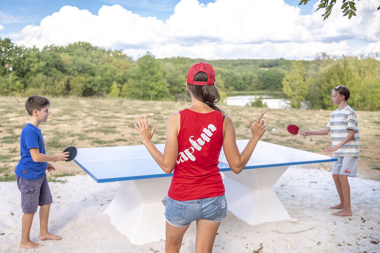 Family playing outdoor table tennis at CAPFUN Ullule campsite in Tournon d'Agenais (47).