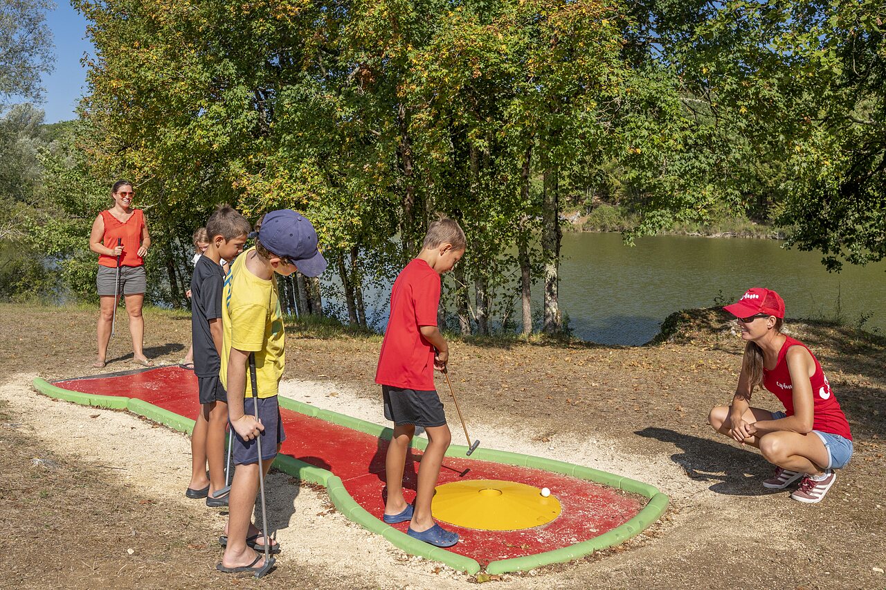 Children playing mini-golf by the lake at CAPFUN Ullule campsite in Tournon d'Agenais (47).