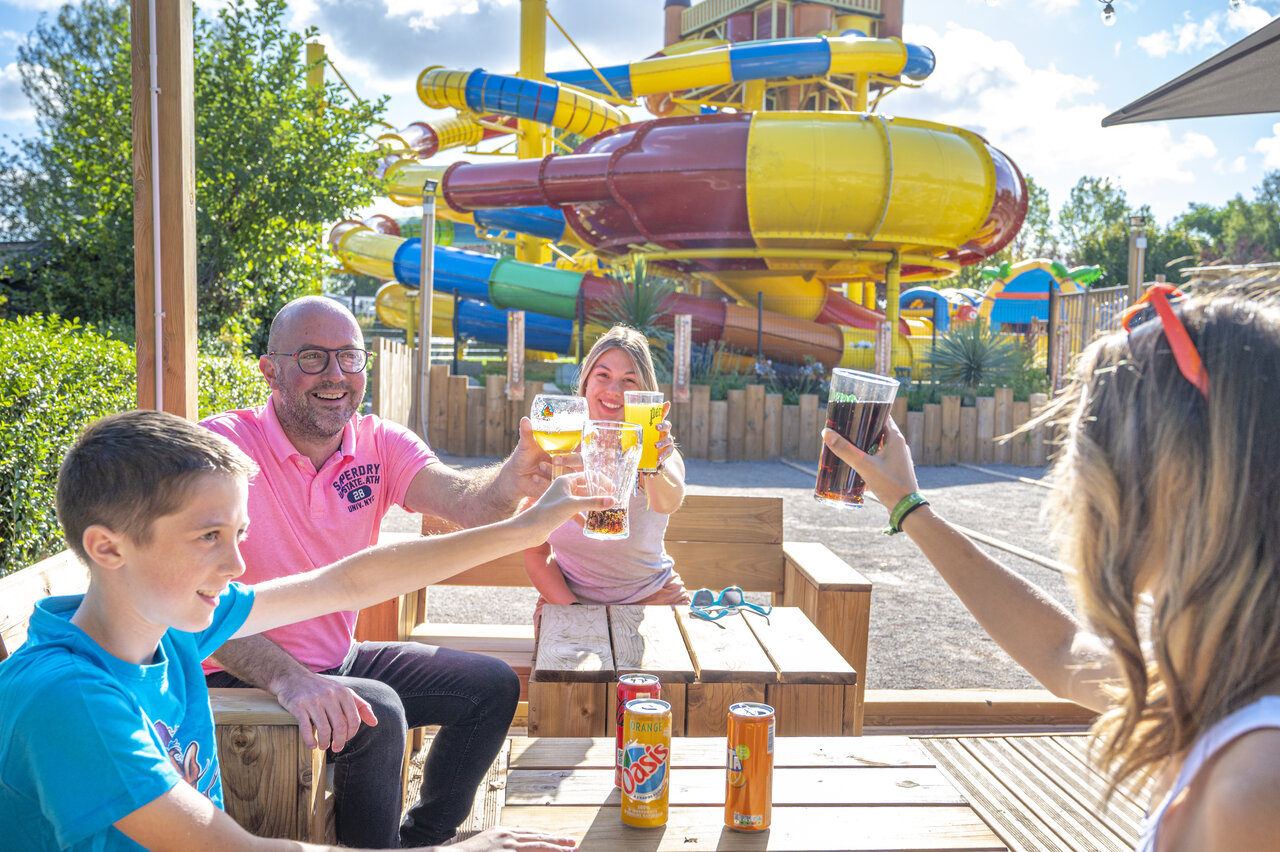 Family toasting at the bar, water slides at CAPFUN Val d'Authie campsite (80).