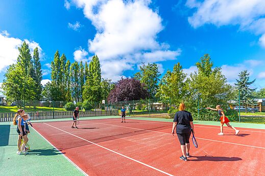 Tennis court with players at CAPFUN Val d'Authie campsite in Villers sur Authie (80).