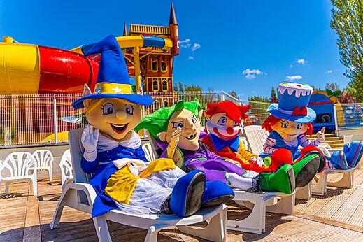 Smiling mascots on chairs, water slides, at CAPFUN Val d'Authie campsite.