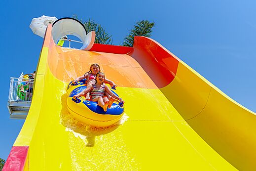 Two children on tube slide down giant water slide at CAPFUN Vignes d'Or, Serignan.