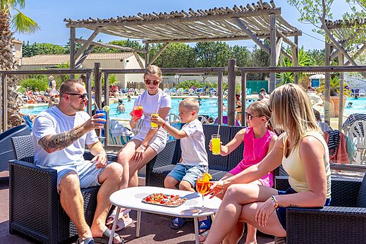 Family at the pool bar with drinks, CAPFUN Vignes d'Or campsite.