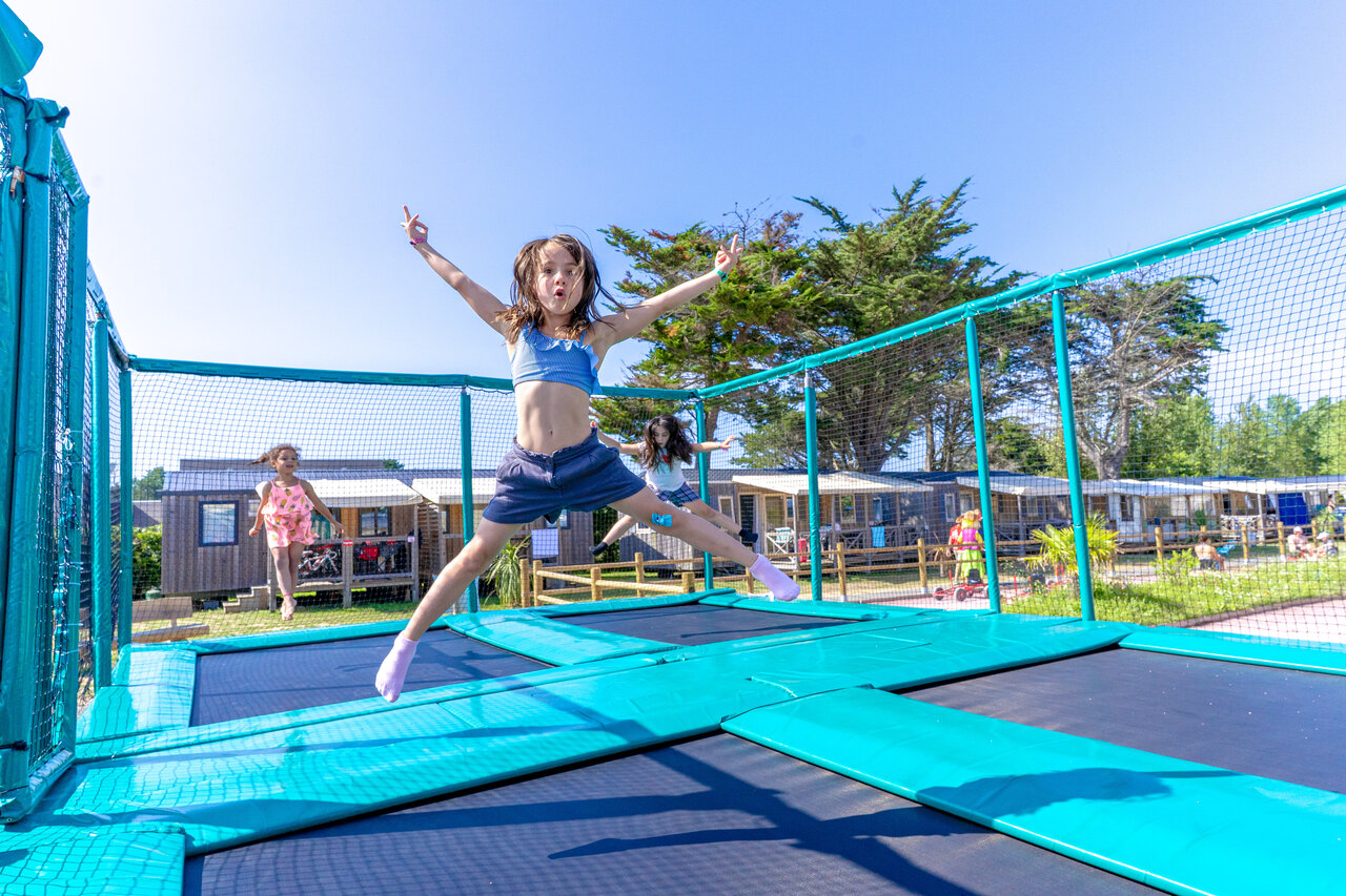 Children jumping on trampolines, Mobil-homes in background at CAPFUN Vikings campsite in Saint Jean de la Rivi�re (50).