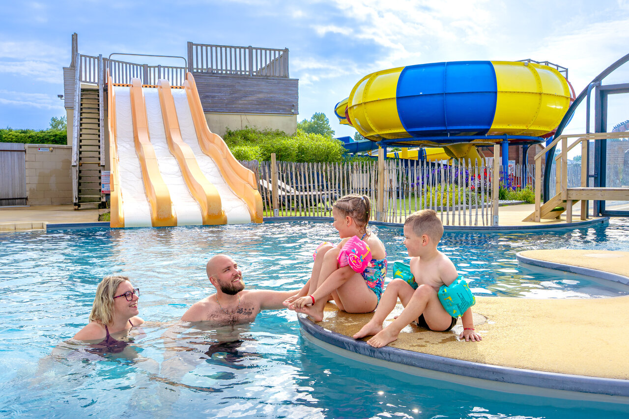 Family enjoying the pool and water slides at CAPFUN Vikings campsite in Saint Jean de la Rivi�re (50).