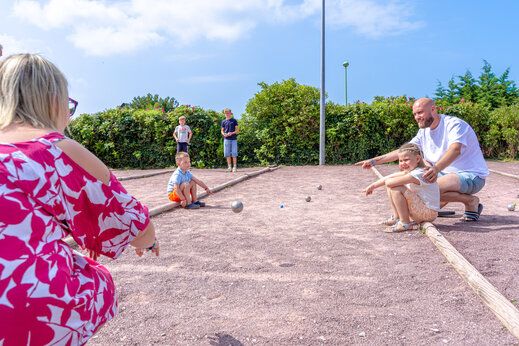 Family playing p�tanque on the court at CAPFUN Vikings campsite in Saint Jean de la Rivi�re (50).