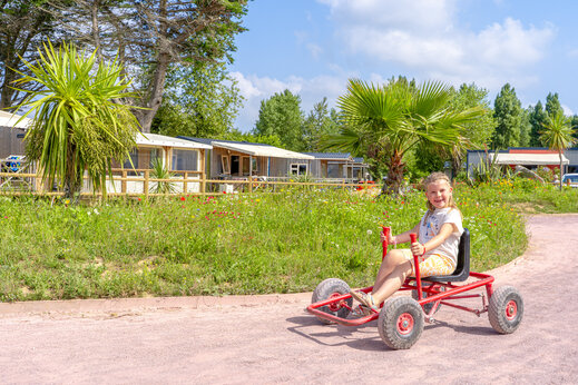 Smiling child on pedal kart at CAPFUN Vikings campsite, Saint Jean de la Rivi�re (50).