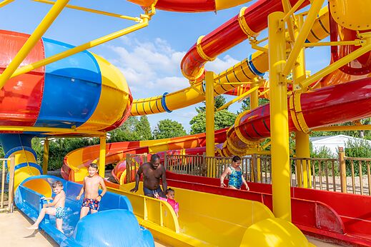 Colorful water slides and water games at CAPFUN Le Village Parisien campsite.