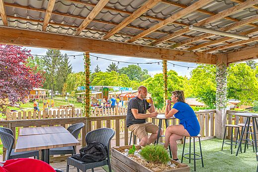 Covered bar, couple at CAPFUN Le Village Parisien campsite in VARREDDES (77).