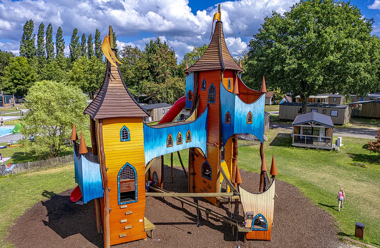 Colorful castle playground with slides and bridges at CAPFUN Vlinderloo campsite in Enschede.